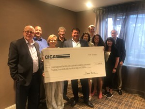 Several members of the captive insurance industry holding a large CICA check to signify a donation to ICCIE